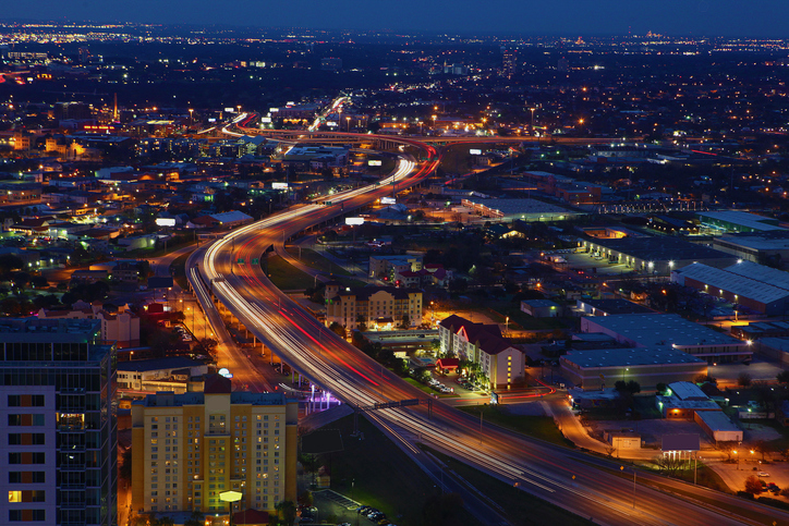 Long exposure nighttime view of San Antonio highway traffic representing drug corridors like I-35 and Hwy 90 targeted by federal prosecutors.